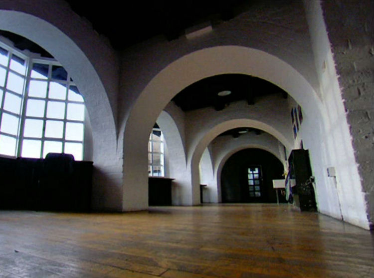 Brick arches behind bay windows of Glasgow School of Art