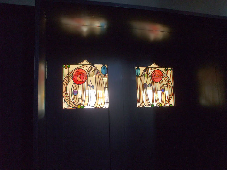 Stained glass with rose emblems in House for an Art Lover 