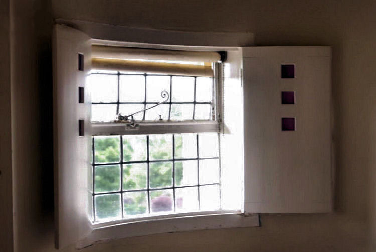 Decorative shutters at window of bedroom at Hill House, Helensburgh