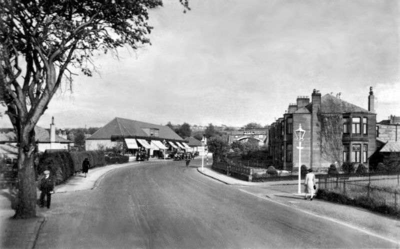 View of shops on Eastwoodmains Road on approaches to railway bridge at Williamwood Station, 1943