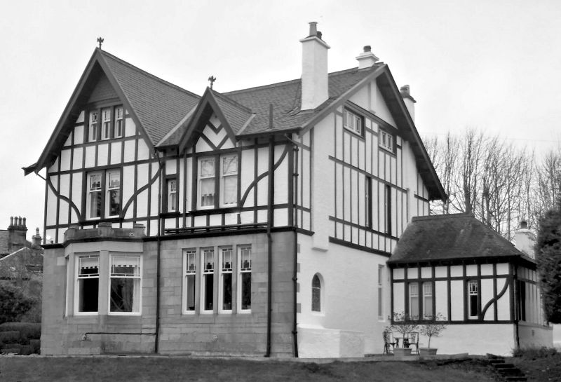 Mock Tudor style detached villa at Giffnock with local sandstone frontage at lower level