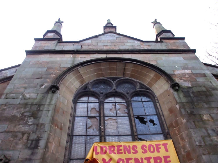 Looking up to damaged windows at Pollokshaws United Free Church
