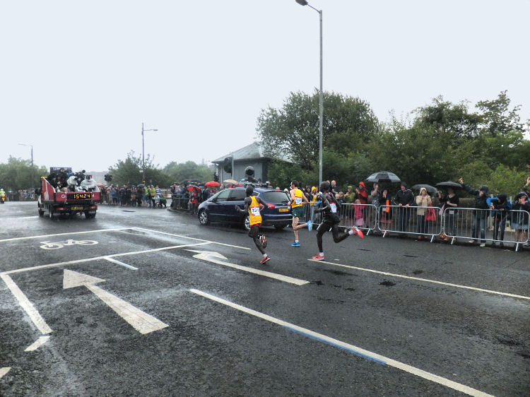 Athletes leading the 2014 Commonwealth Games marathon passing  Strathbungo Station