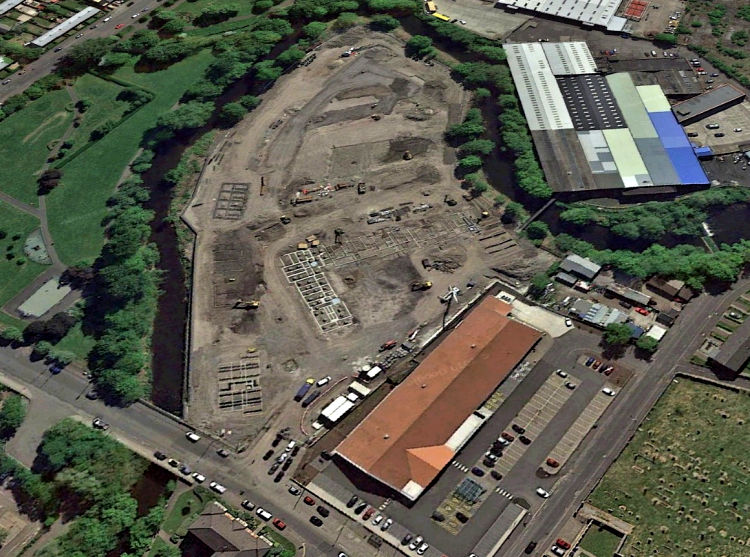Aerial view of cleared site of demolished factories and warehouses surrounded by  White Cart Water, Pollokshaws