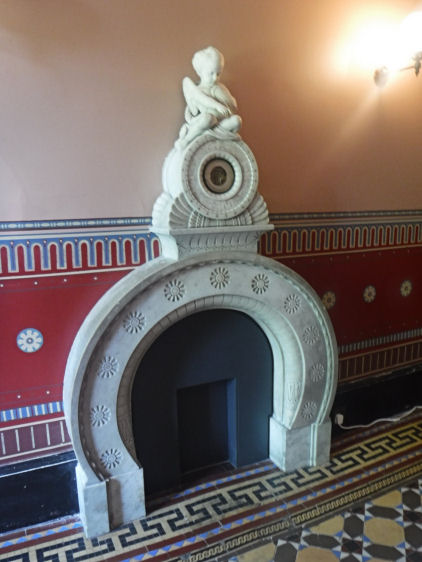 Fireplace with restored wall decoration at entrance hall at Holmwood House
