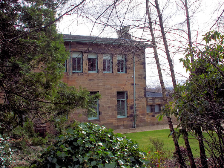 Glimpse of Maria Villa through garden shrubs
