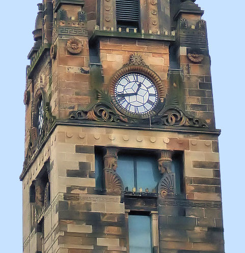 Clock and sculpted faces at St Vincent Street Church, Glasgow